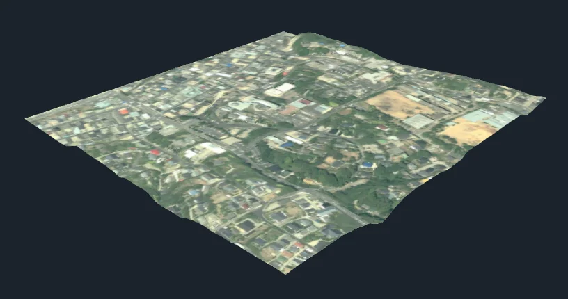 西之表の市街地 600 m 四方。国土地理院の空中写真が、起伏のある地形の面に貼られ、斜め上から見た3次元の画。道や建物が地形に沿って見える